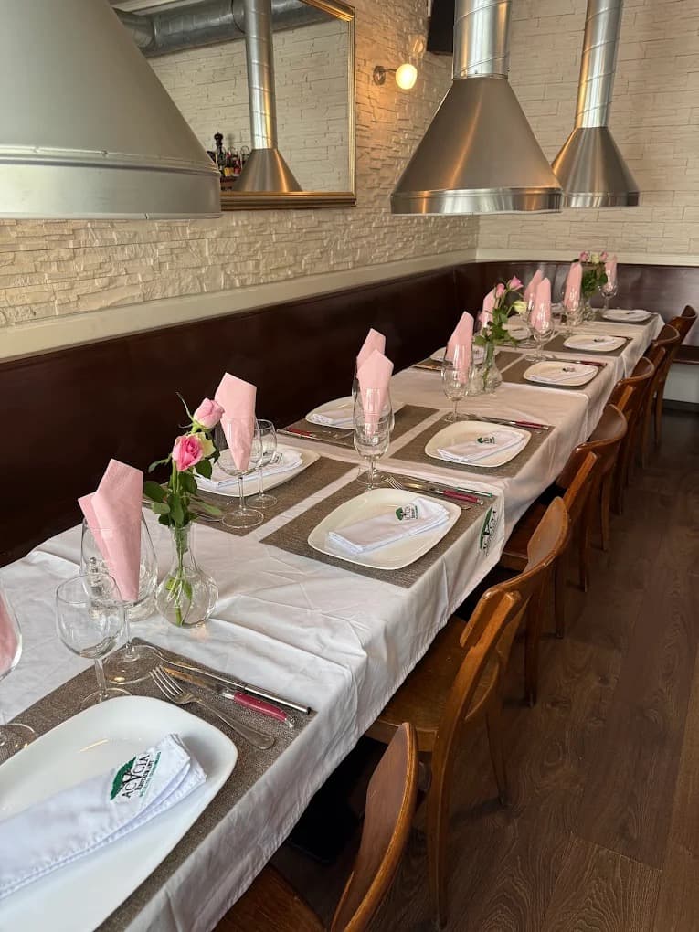 Grande tablée dressée au Restaurant Acacia, nappe blanche et roses